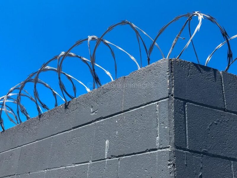 barbed wire fence on a prison wall